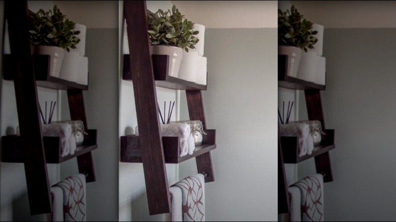 A floating ladder shelf mounted onto a bathroom wall