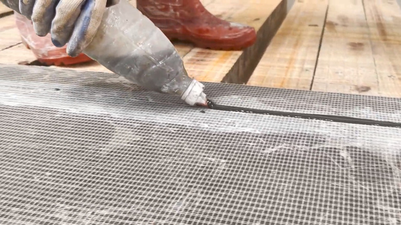 Person applying reinforcing to under part of marble slab