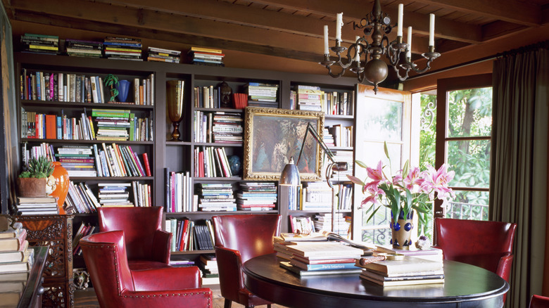 Dark academia reading room with tall bookshelves and leather armchairs