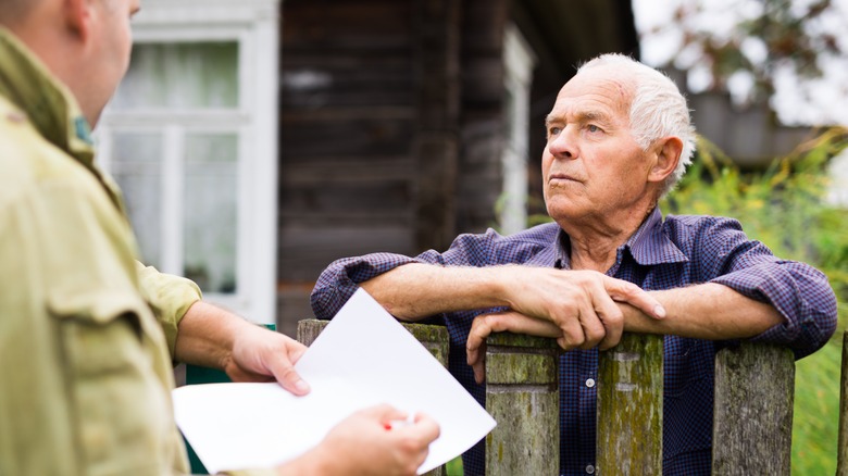 two men talking by gate