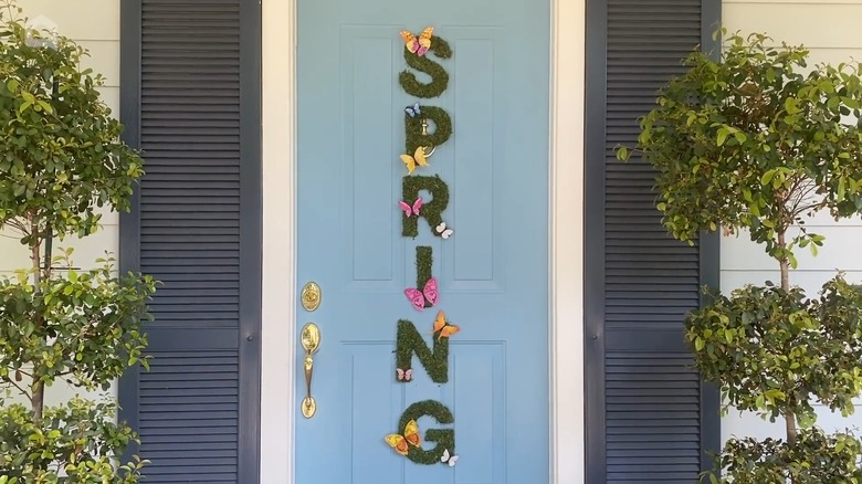 Wooden letters on front door arranged to spell "spring"