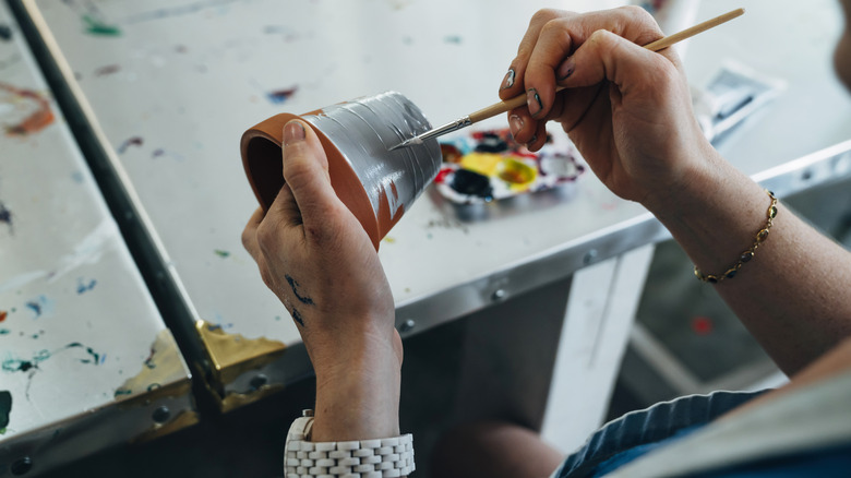 close-up of hands painting a flower pot