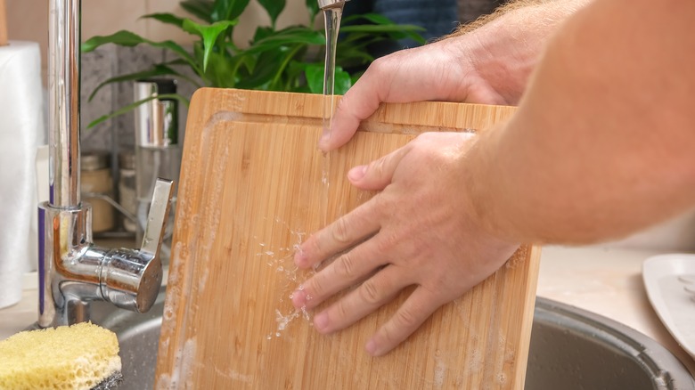 person washing cutting board