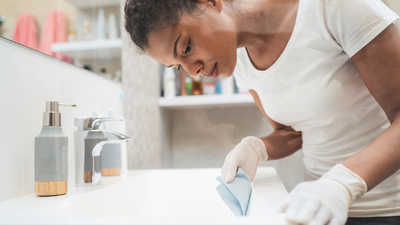 woman cleaning bathroom sink