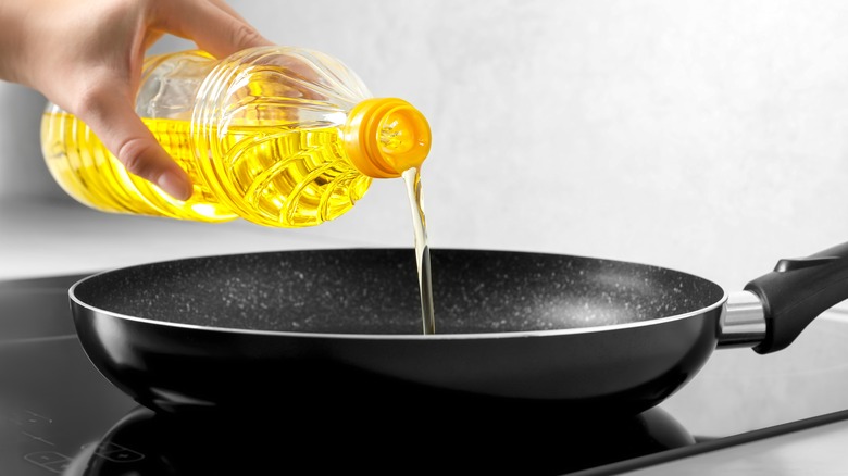 Cooking oil being poured in frying pan