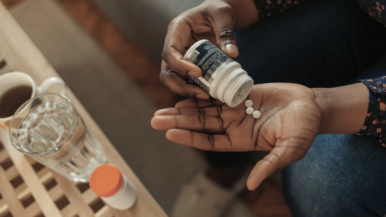 Woman pouring out aspirin into her hand