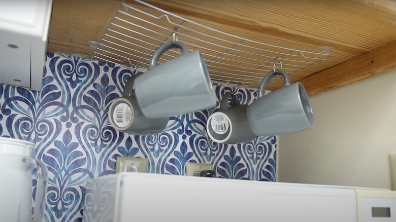 mugs hanging under cabinet