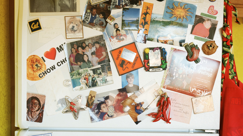 Cluttered fridge with pictures