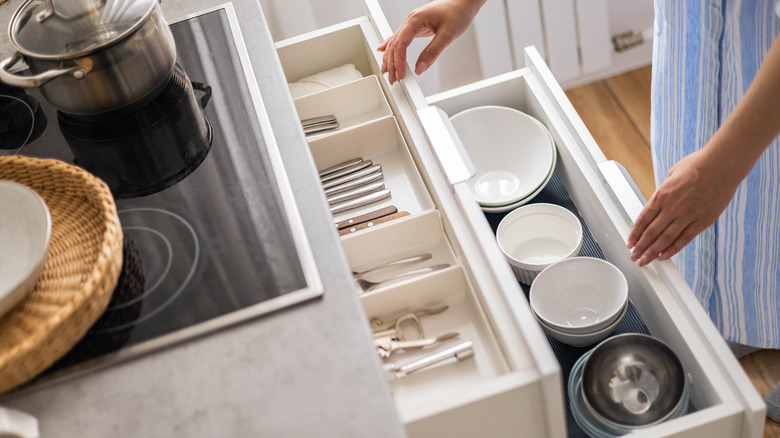 Hands reaching in kitchen drawer