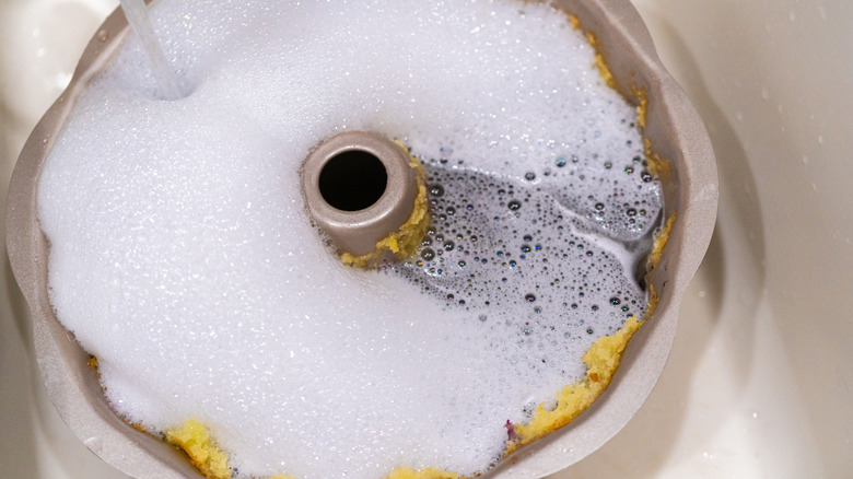 bundt cake pan soaking in soapy water