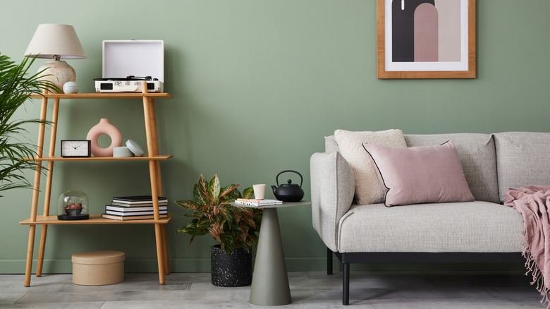 Sage walls in living room with dusty pink touches