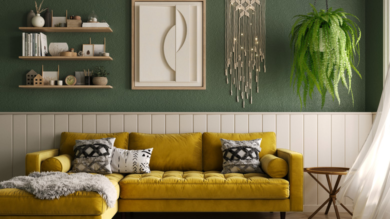 Yellow couch in green living room with wooden accents