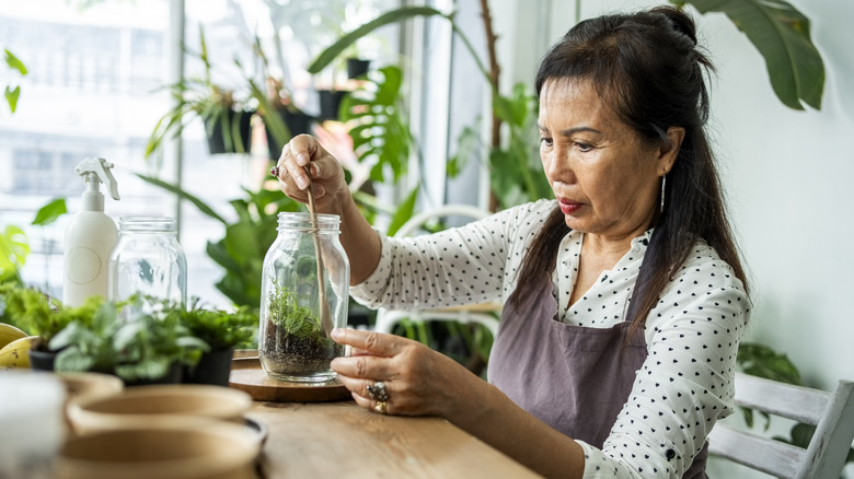 Woman gardening with jar