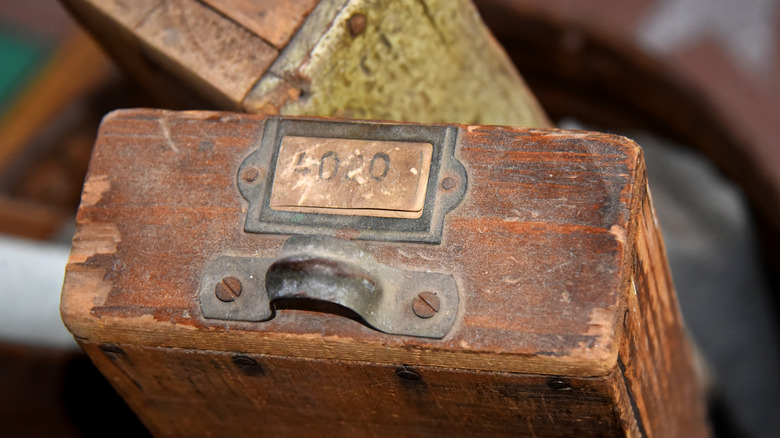 Two very old filing drawers with metal handles and card slots