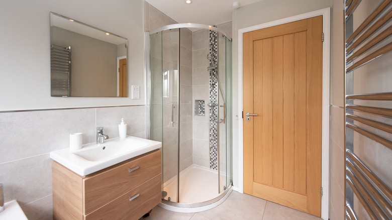 Clean corner shower with glass doors in bathroom