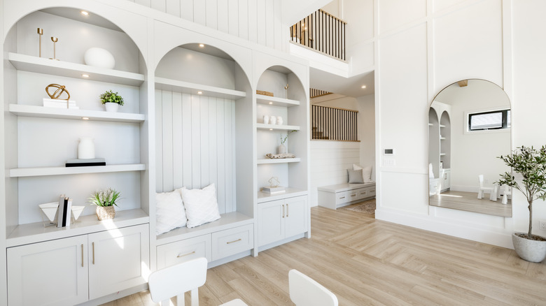 A room in a home with arched built-in shelves