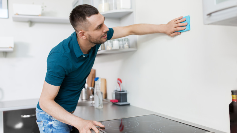 Person scrubbing kitchen walls