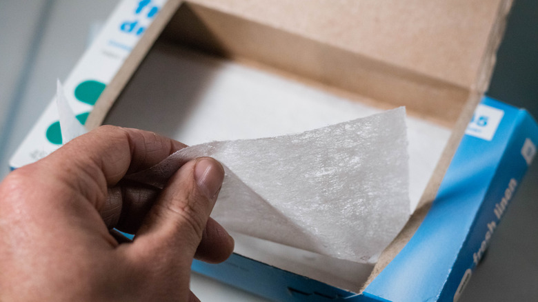 Pulling a dryer sheet from the box