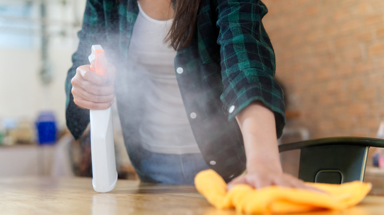 Spraying disinfectant cleaner on a counter