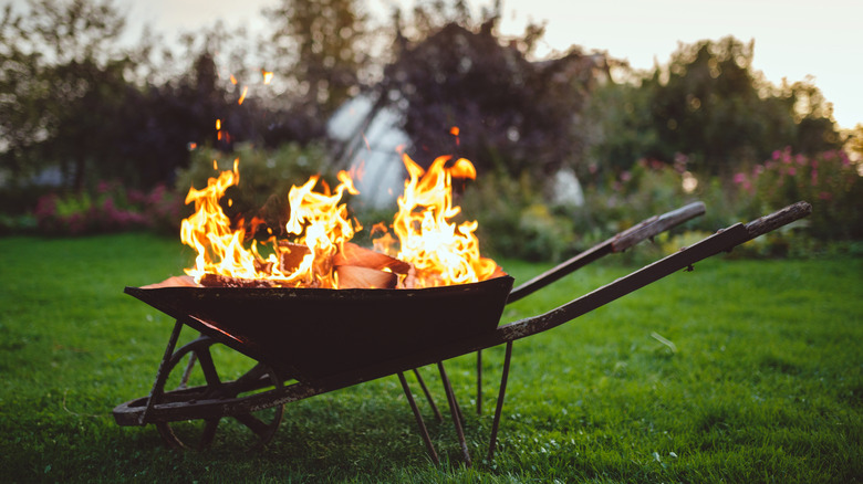 rusted wheelbarrow with fire