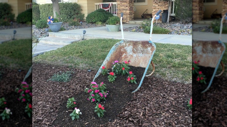 wheelbarrow decoration in garden bed