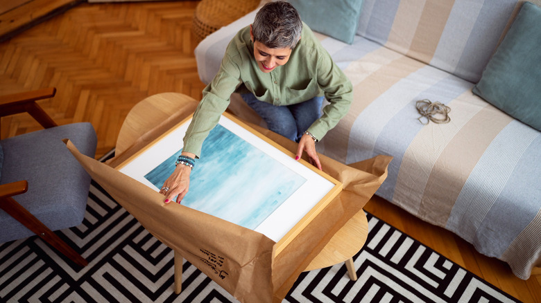 woman wrapping art in paper