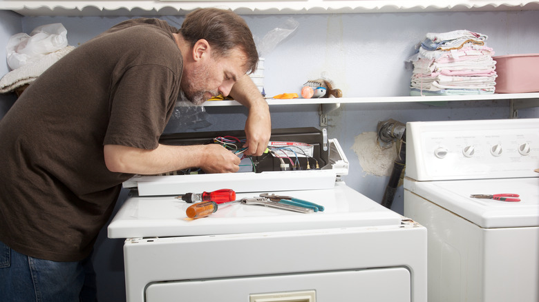 man trying to fix dryer