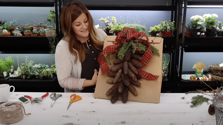 woman showing off DIY pinecone decor