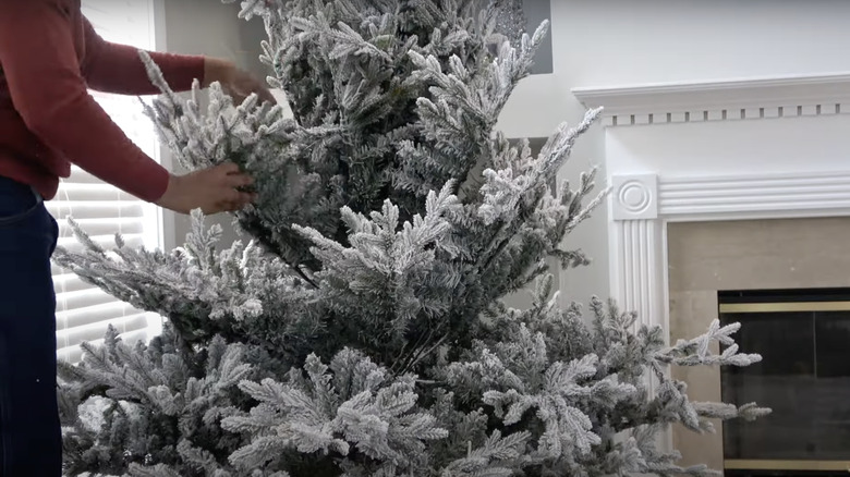 man unboxing fake snowy christmas tree