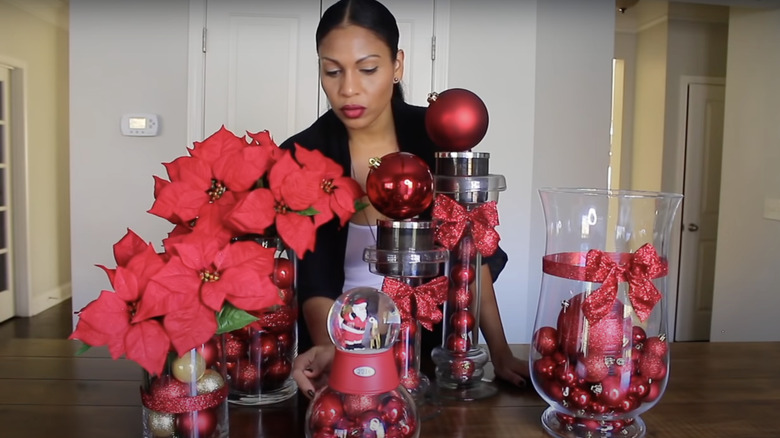 clear vases filled with red ornaments