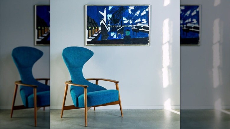 Blue IKEA CAVELLI armchair in front of a painting