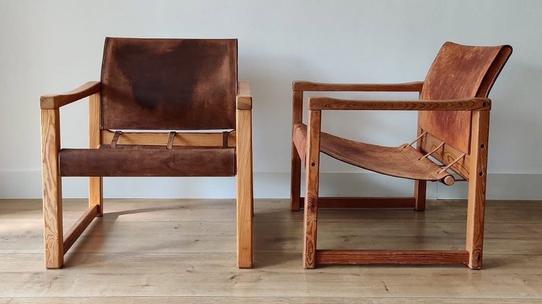 Two brown leather and wood chairs