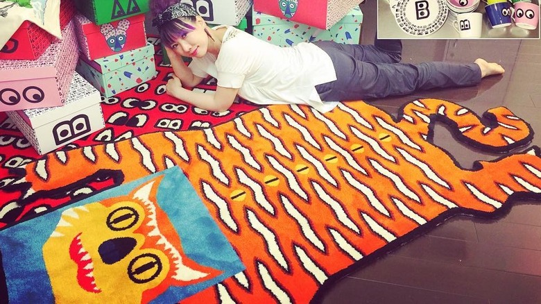 Woman on the floor with tiger rug and colorful boxes