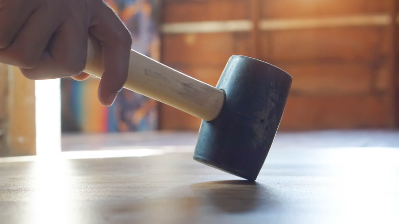 rubber mallet tapping a floor