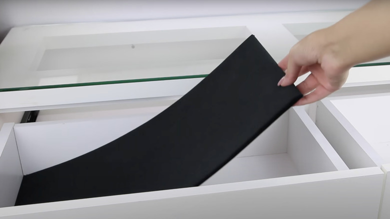 woman laying velvet liners in white drawers