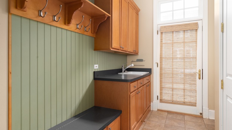 green and wood mudroom with sink