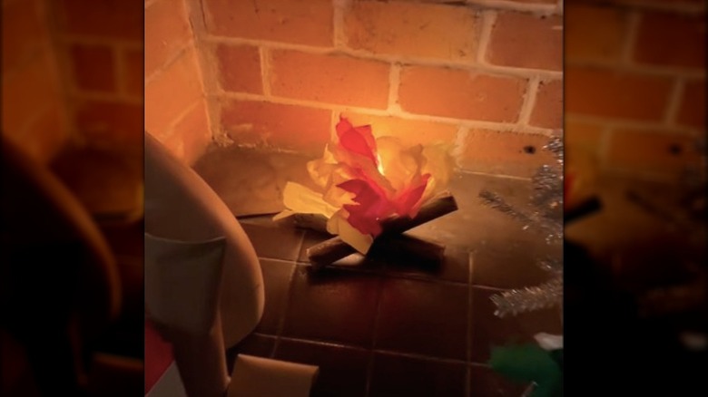 Fake fire made from tissue paper and paper towel rolls in a fireplace