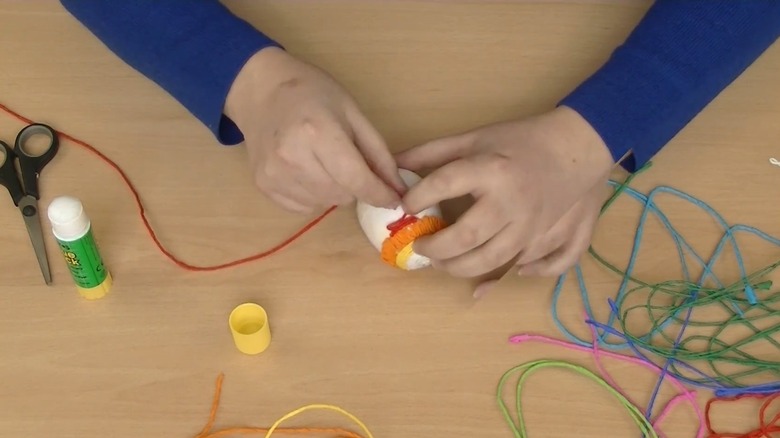 Person decorating an Easter egg with tissue paper