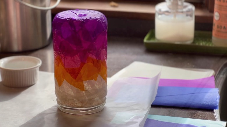 Glass jars covered with purple, orange, and white tissue paper