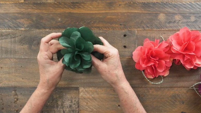 Person making mini flowers using tissue paper