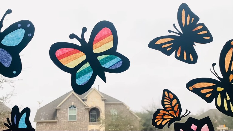 colorful butterfly and flower suncatchers made from tissue paper on a window