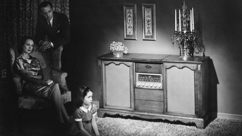 family listening to a Maganox radio in old black-and-white photograph