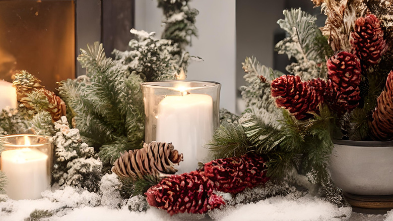 A table top display with glass candle jars and pine cones creates wintry ambience.