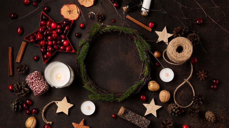 A supply of materials for making a natural holiday display is spread out on a table.