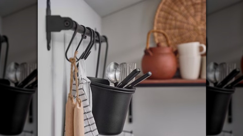 Black metal storage hooks on a wall-mounted rail