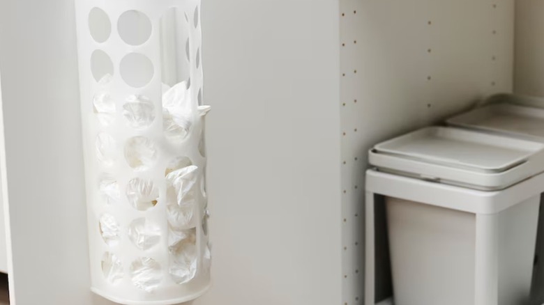 White plastic bag dispenser mounted on a cabinet door