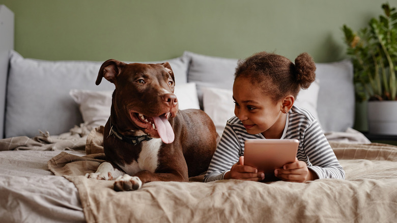 female child and dog on bed