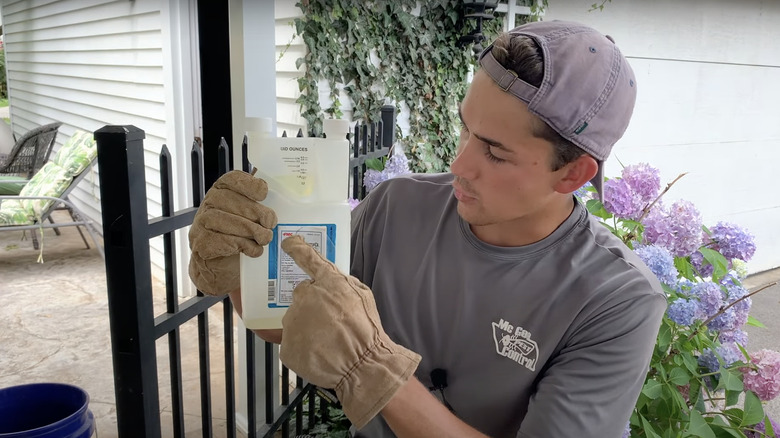 young man reading pesticide ingredients