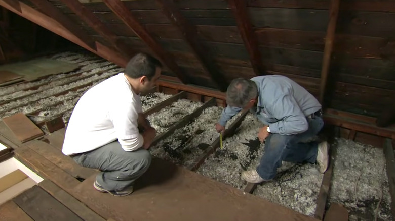 men examining attic insulation