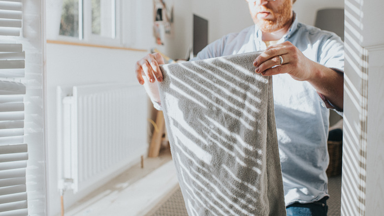 A man holding up a towel